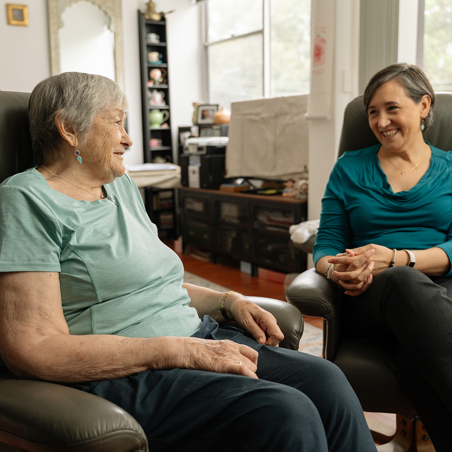 Older woman chatting with a support worker during a home visit.