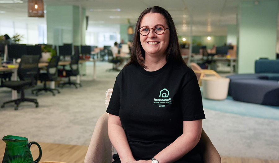 HomeMade team member sitting and smiling in an office.